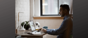 Blog post header image showing profile view of youngish man sitting at desk with laptop. Posted by Charlotte Whitehead, UK Career Coach at Career Practic.